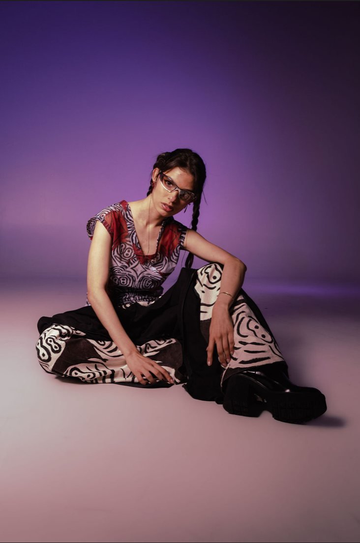 Entre capas: look femenino sobre fondo violeta